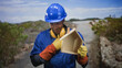 © Krakenimages.com - Man builder in blue hardhat wearing ear protection holding small wooden house model with gloved hands in building; pride duty.