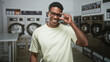 © Krakenimages.com - Man smiling and adjusting glasses with one hand beside stacked front loading washers in a laundromat building, turning head to the right; contentment.