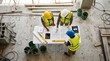 © Lambung - Diverse team of construction professionals reviewing building blueprints on a site.