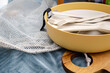 © Ina - Closeup of reusable picnic utensils stored in bowl with mesh bag on textile background. Sustainable outdoor dinner, zero waste concept, eco friendly lifestyle, plastic free food preparation to travel.