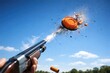 © AkuAku - Shooting clay pigeon in midair under a sunny blue background