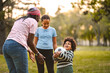 © Jelena - Family playing soccer outdoors with children in park