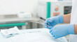 © OlgaNeuroArt - Gloved hands holding surgical forceps in a sterile environment. Medical professional preparing for surgery. Close up of stainless steel medical instrument