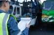 © JD Studio - Engineer holding a checklist during crane inspection inside a maintenance bay, supporting safety compliance, equipment assessment, and heavy lifting readiness