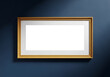 © MDSHAHINUL - Empty horizontal wooden picture frame hanging on a dark blue wall with subtle lighting template horizontal background copy space interior rectangle