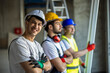 © Mediteraneo - Construction supervisor looking at camera with team observing project progress.