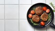 © Jeremy - delicious grilled meat patties tomatoes and rosemary in grill pan on white tiled table closeup space for text