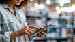 © Kateryna - Hands of young businesswoman positive and holding tablet in bright automotive hardware store professional customer service in clean contemporary retail environment with organized