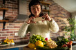 © Davor - Woman photographing fresh vegetables with smartphone in home kitchen