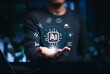 © Supatman - AI automation platform and smart technology integration concept. Person holding artificial intelligence chip with icons for cloud, security, analytics, industry, tools, network, digital transformation