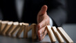 © A2Z AI  - Professional's Hand Stops Falling Dominoes, Illustrating Risk Management, Crisis Prevention, and Business Stability in a Controlled Sequence