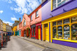 © Kirk Fisher - A narrow street of vibrant, multicolored storefronts in the historic center of Kinsale, a fishing port town in County Cork, Ireland.