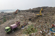 © AmazingAerialAgency - Aminbazar, Bangladesh - 26 January 2025: Aerial view of the Aminbazar landfill with excavators and people scavenging through massive piles of waste under a hazy sky.