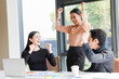 © Tanison - A group of multi-ethnic young professionals, aged 20-30, working together around a laptop in a bright office with large windows. The images show brainstorming, teamwork, celebration, and success in a