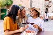 © Xavier Lorenzo - Female friends laughing together with red wine outdoors. Young women enjoying relaxed lifestyle moment in European city. Lifestyle and friendship concept.