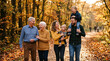 © GfxAkash - A joyful multi-generational family walking through a golden autumn forest path