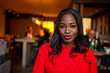 © EDUARDOIVAN - Smiling young black woman enjoying cozy cafe atmosphere