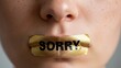 © Muhammad - Close-up of a person with a gold foil badge covering their mouth with the word Sorry printed on it symbolizing apology or silence in communication and social interactions
