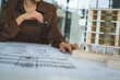 © PIC SNIPE - Female Architect Analyzing Modern Building Model