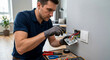 © For You Retouch - A professional electrician in a blue polo shirt and gloves using a screwdriver to fix a power outlet on a modern interior wall.