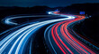 © Jacqueline - Curving highway at night showcasing captivating light trails from vehicles.