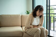 © Chanakon - Mature elderly woman suffering stomach pain while sitting alone at home with senior health problems illness, urgent medical care needs and health life insurance in retirement lifestyle