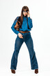 © wedmoments.stock - Young woman in denim jeans and shirt standing in minimal studio space. Concept modern apparel and everyday fashion.