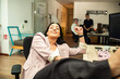 © Davor - Confident businesswoman relaxing at desk in modern office with coworkers