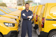 © Ljupco Smokovski - Mechanic posing in front of a fleet of yellow vans