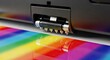 © putri - Close up view illustrates the operation of a modern digital printing mechanism applying vibrant colors onto a surface.