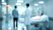 © Subin - A blurred scene in a hospital, depicting healthcare workers attending to patients in a medical setting.