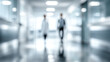 © Subin - Blurry image of medical professionals walking through a hospital corridor, illustrating teamwork in healthcare.