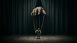 © Edi - Puppeteer hand controlling small wooden marionette on dark theater stage boards.