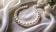 © Marie K - pearl necklace rests on soft white fabric elegant jewelry accessory shines with delicate luster classic feminine style evokes luxury and sophistication for special events