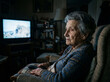 © neyostudio - Elderly Woman Watching Television in Dimly Lit Room Holding Remote