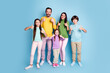 © deagreez - Happy family of five giving thumbs up together in colorful casual outfits on pastel blue studio background