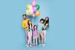 © deagreez - Happy family portrait with colorful balloons celebrating together against a pastel blue background, parents and children smiling in casual clothes