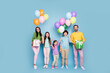 © deagreez - Happy family celebration with parents and children holding colorful balloons and birthday gifts, smiling in casual clothes against a pastel blue studio background