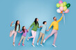 © deagreez - Family holding colorful balloons and playfully jumping together against a blue background, parents and children enjoying a joyful, carefree moment