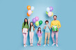 © deagreez - Happy family celebrating a birthday with colorful balloons and wrapped gifts against a pastel blue studio background