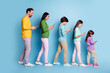 © deagreez - Family walking in a row looking at smartphones — parents and children using mobile phones against a blue background