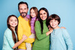 © deagreez - Smiling happy family portrait with parents and three children in colorful casual clothing against a blue background showing togetherness and affection