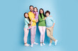 © deagreez - Smiling family portrait of parents with three children standing together against a blue background, casual clothing, warm togetherness and happy family moment
