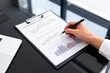 © baojun - Person analyzing data charts on clipboard