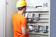 © New Africa - Electrician with screwdriver checking electrical meter indoors