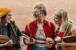 © La Famiglia - Happy diverse students laughing together on campus