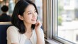 © AiPhoto - 電車で映画館へ向かいながら窓の外を眺めて微笑む女性
