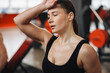 © New Africa - Tired woman with sweat on her body training in gym