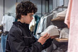 © Светлана Мищенко - Teenage Boy Shopping for Sneakers in Shoe Store - Youth Fashion Footwear Consumer and Retail Shopping.  Gen Z consumer shopping behavior, teen fashion choices and personal style development.
