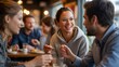 © MDMasud - Diverse group of friends laughing and talking while enjoying a meal at a trendy cafe.